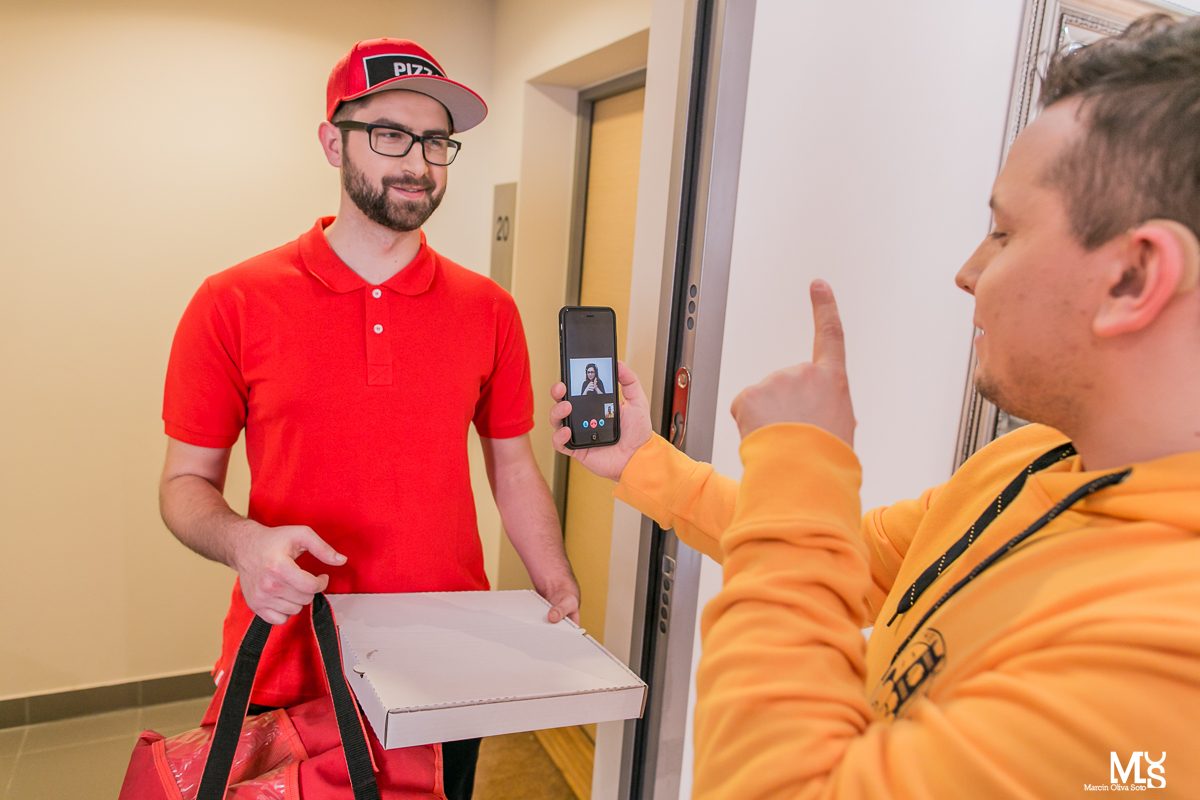 Osoba Głucha używa wideotłumacza w telefonie przy odbiorze dostawy